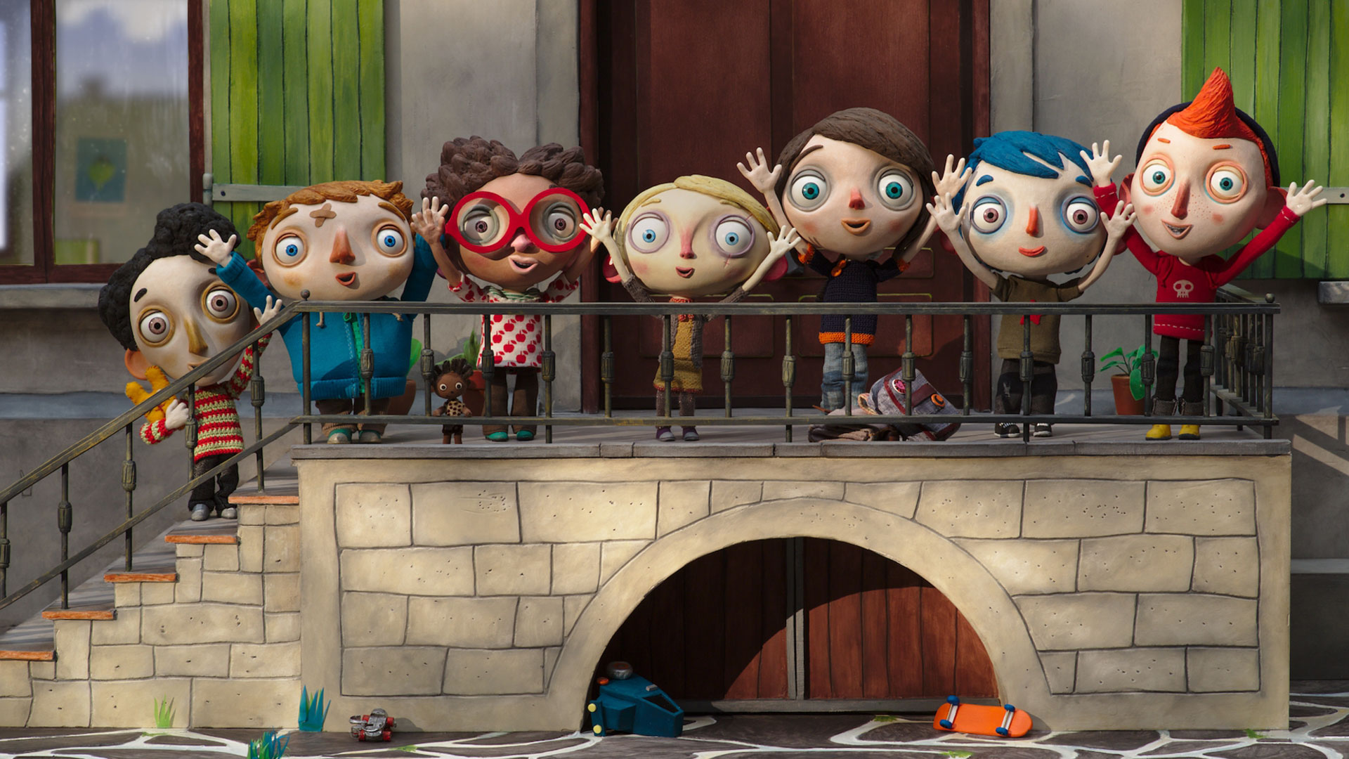 Filmstill aus dem Animationsfilm "Mein Leben als Zucchini": Die sieben kleinen Heimbewohner stehen an dem Geländer einer Steintreppe und reißen freudig die Arme in die Luft.